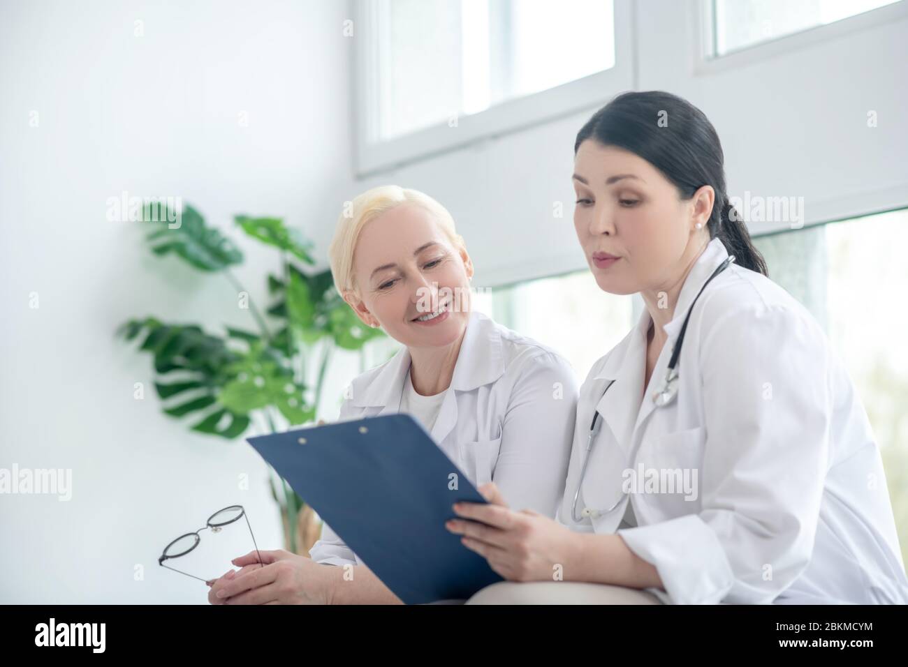 Two female doctors reading the prescription list Stock Photo