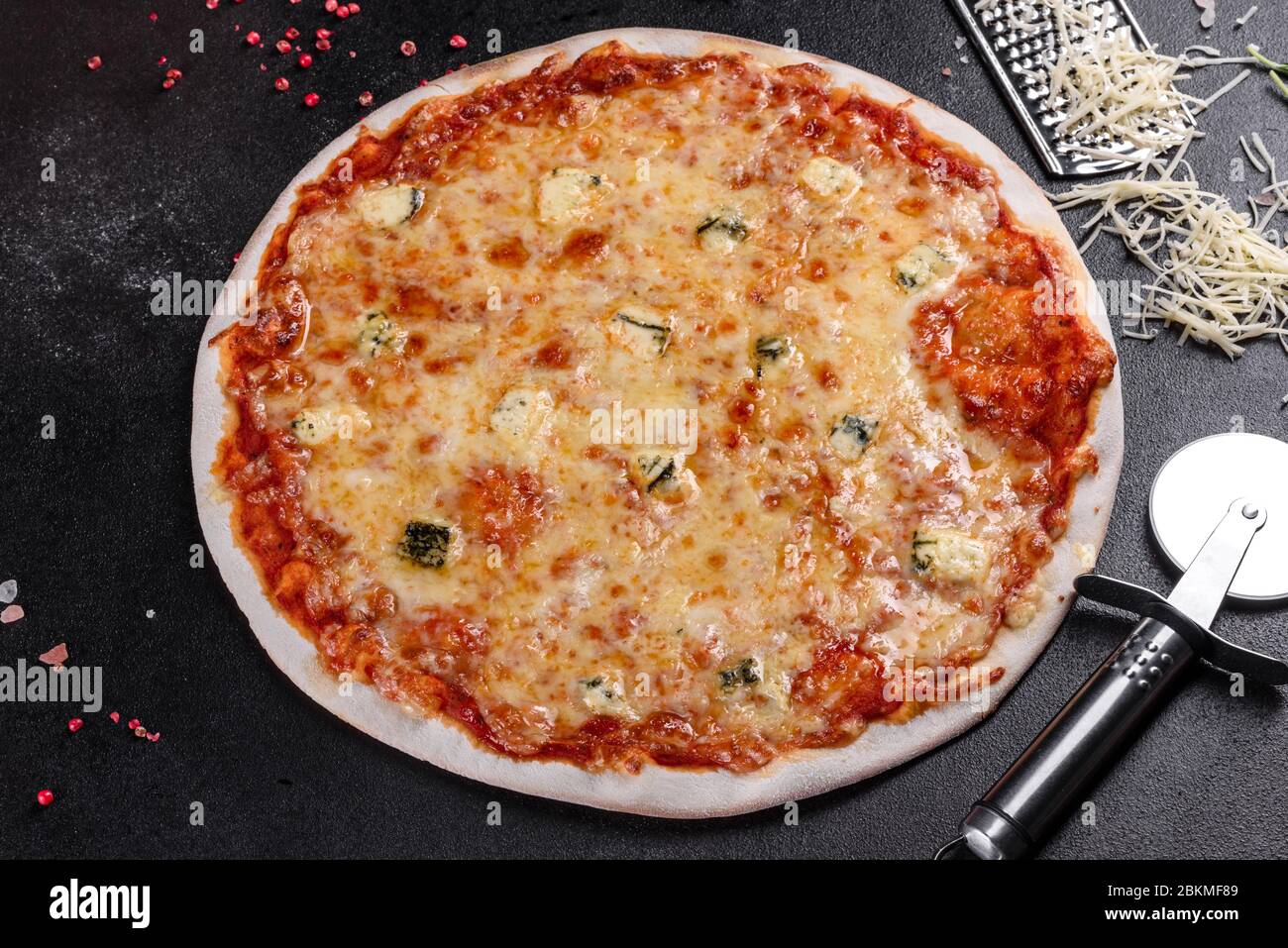 Delicious fresh oven cooked pizza four cheeses on cozy restaurant table