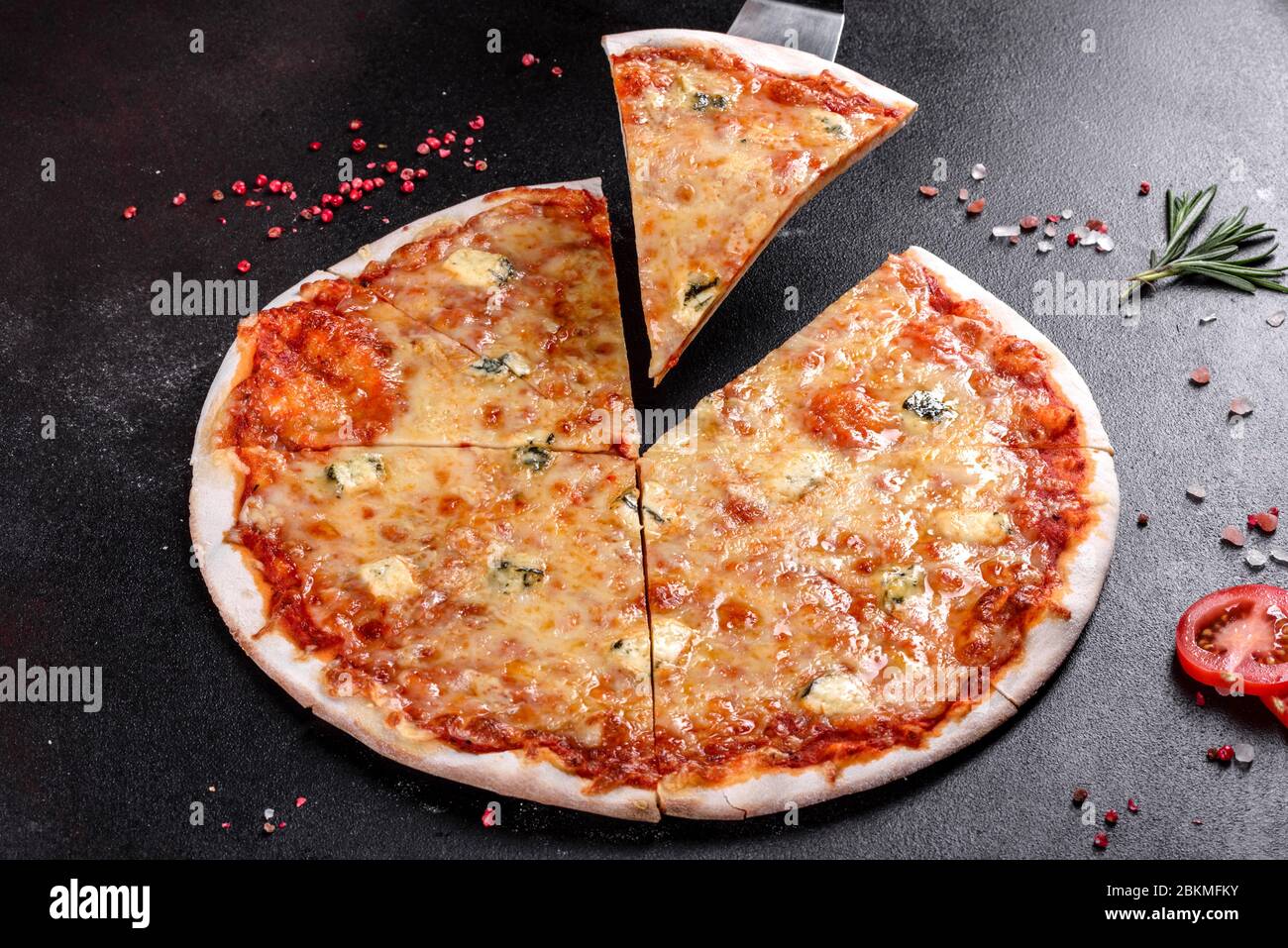 Delicious fresh oven cooked pizza four cheeses on cozy restaurant table