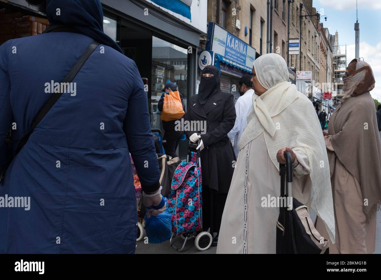 Members of the Islamic community in Whitechapel in east London go about their daily business during the holy month of Ramadan as the UK continues in lockdown to help curb the spread of the coronavirus. Stock Photo