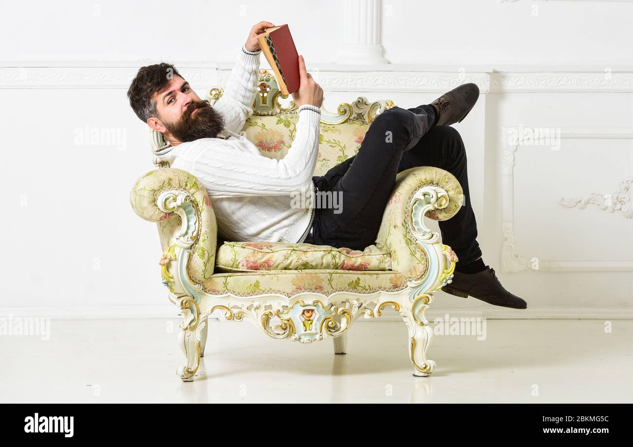 Intelligent concept. Man with beard and mustache sits on armchair and