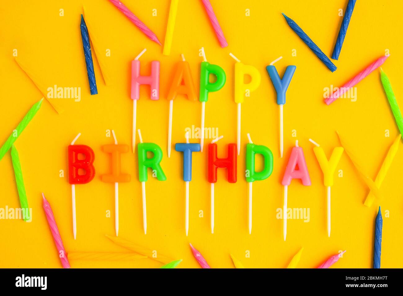 Happy Birthday candles on yellow background. Bright color wallpaper