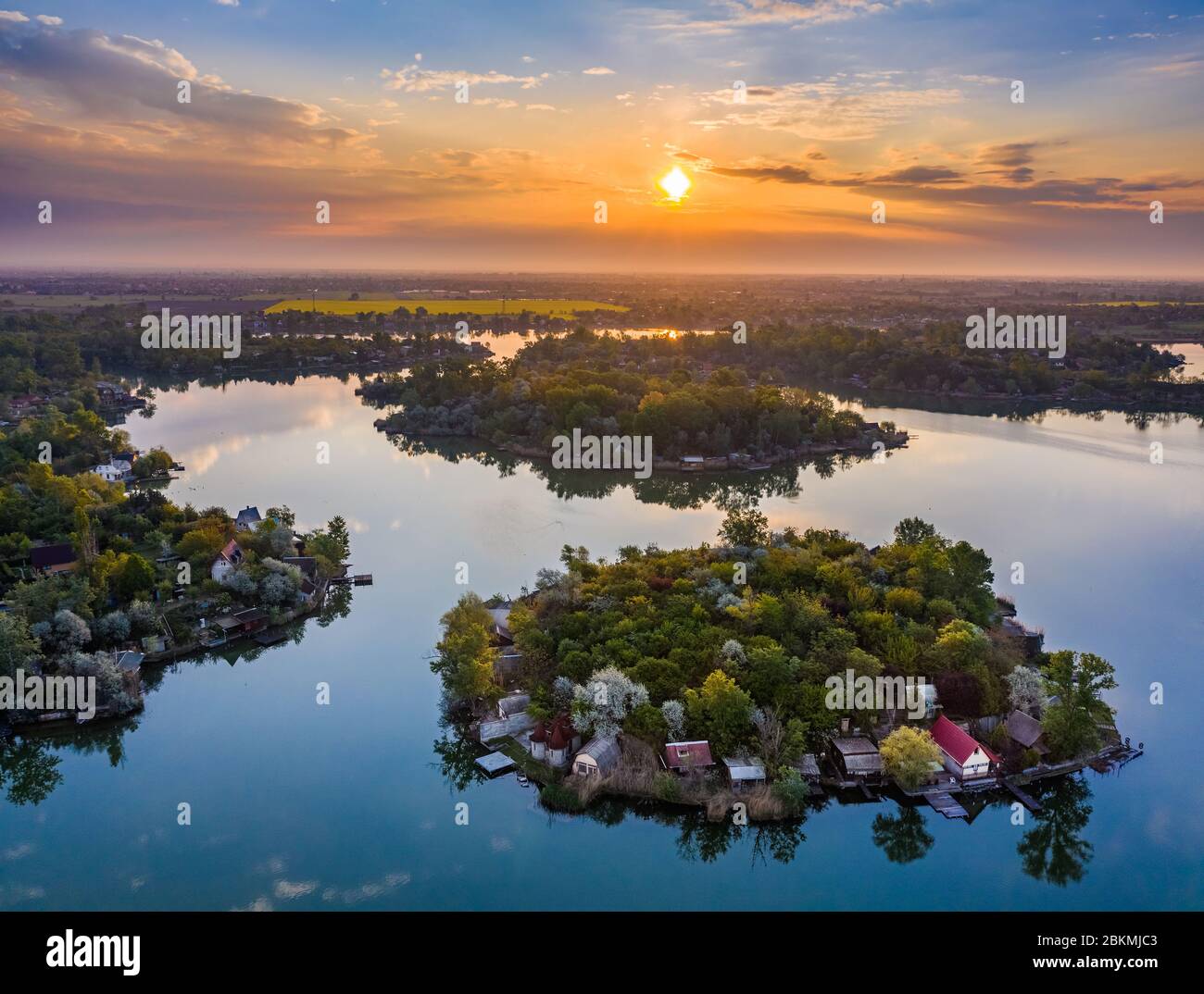Budapest, Hungary - Aerial view of small fishing island on Lake Kavicsos (Kavicsos to) of Csepel district with a warm sunrise and reflecting clouds. T Stock Photo