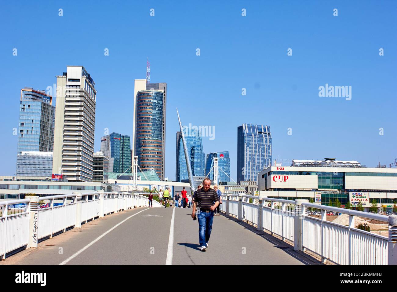 People are walking over white bridge in Vilnius Stock Photo