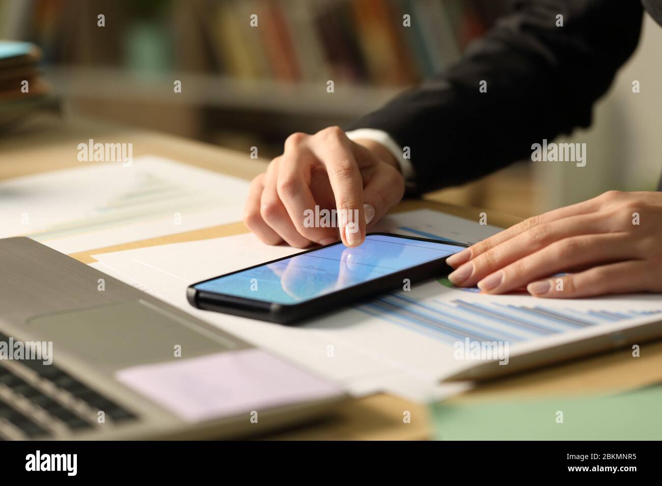 Close up of entrepreneur woman hands signing contract on smart phone with finger at night Stock Photo