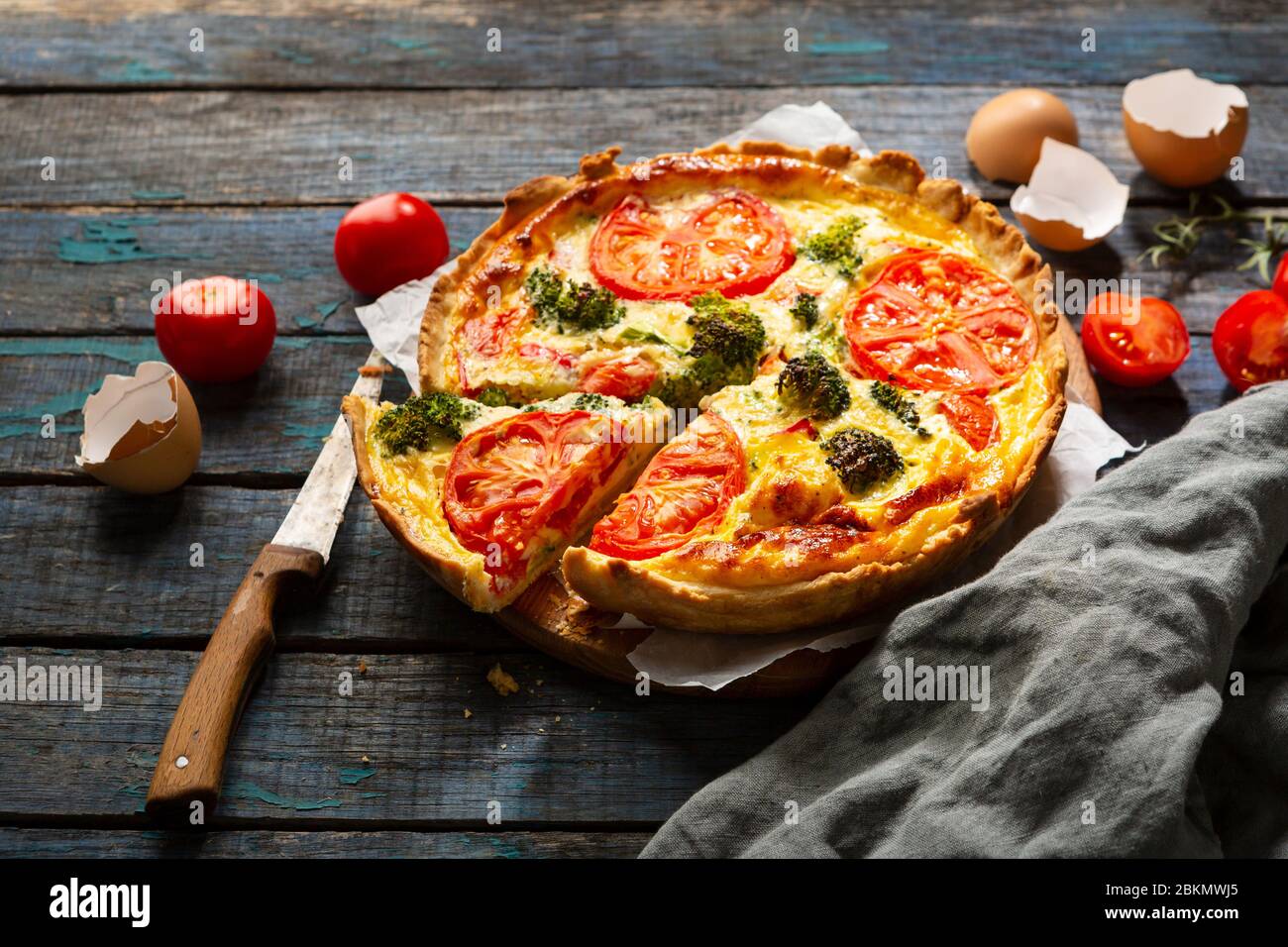 Quiche lorraine with broccoli and cheese on  wooden background. Stock Photo