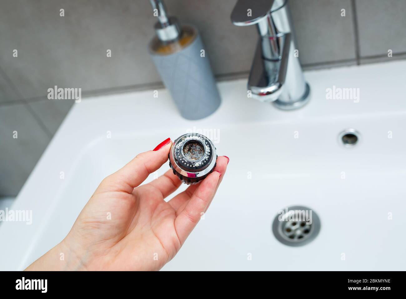 Rotary nozzle on the mixer to adjust the flow of water. White bathroom sink for washing hands