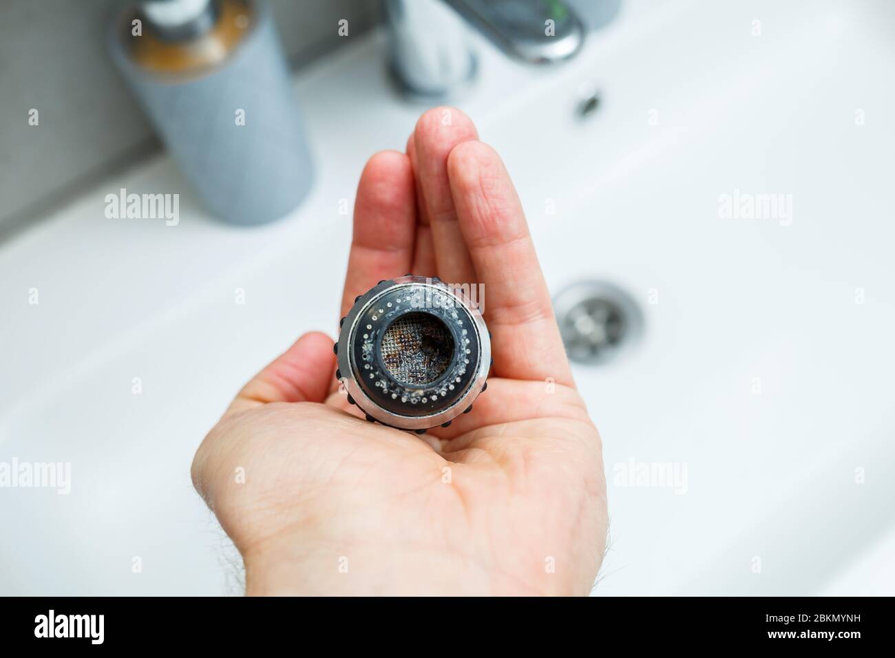 Rotary nozzle on the mixer to adjust the flow of water. White bathroom