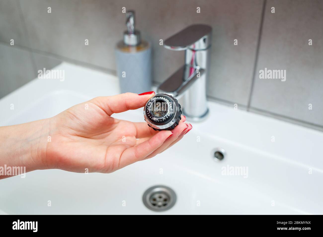 Rotary nozzle on the mixer to adjust the flow of water. White bathroom