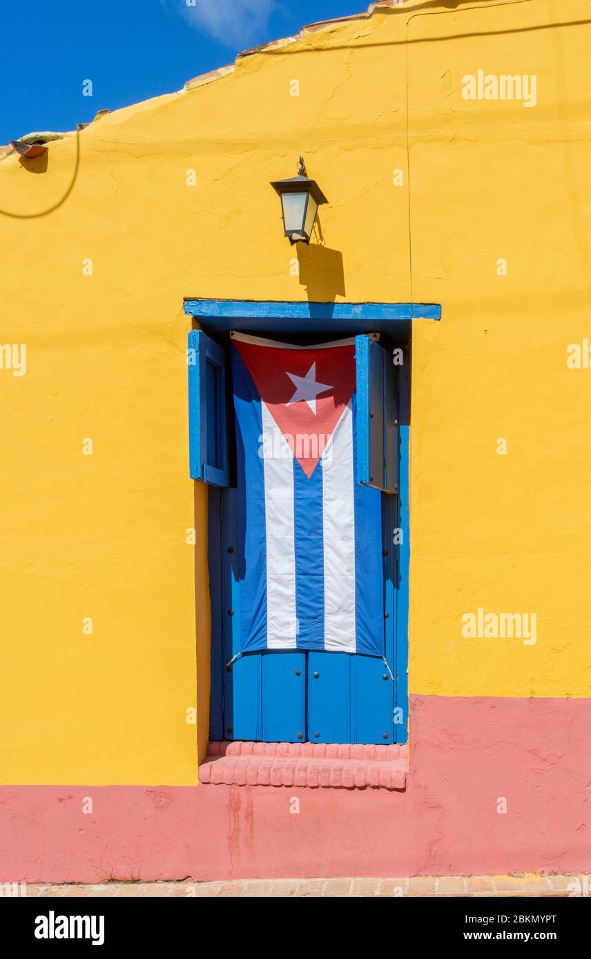 cuban fag hanging in a window on a yellow wall Trinidan, Cuba Stock Photo