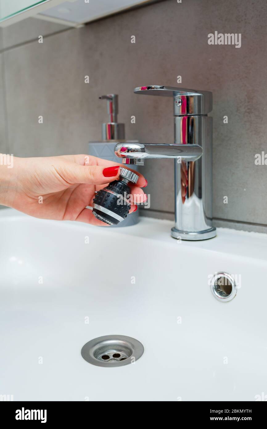 Rotary nozzle on the mixer to adjust the flow of water. White bathroom