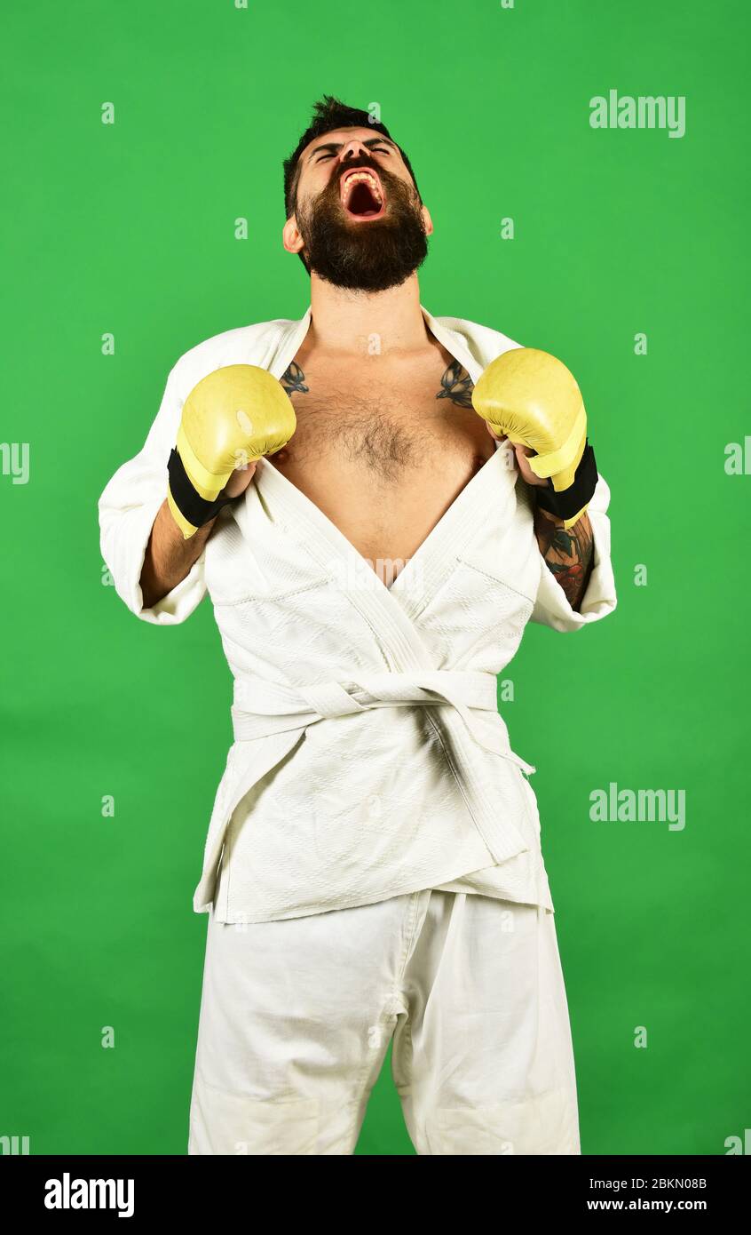 Training and combat concept. Man with beard in white kimono on green  background. Karate man with