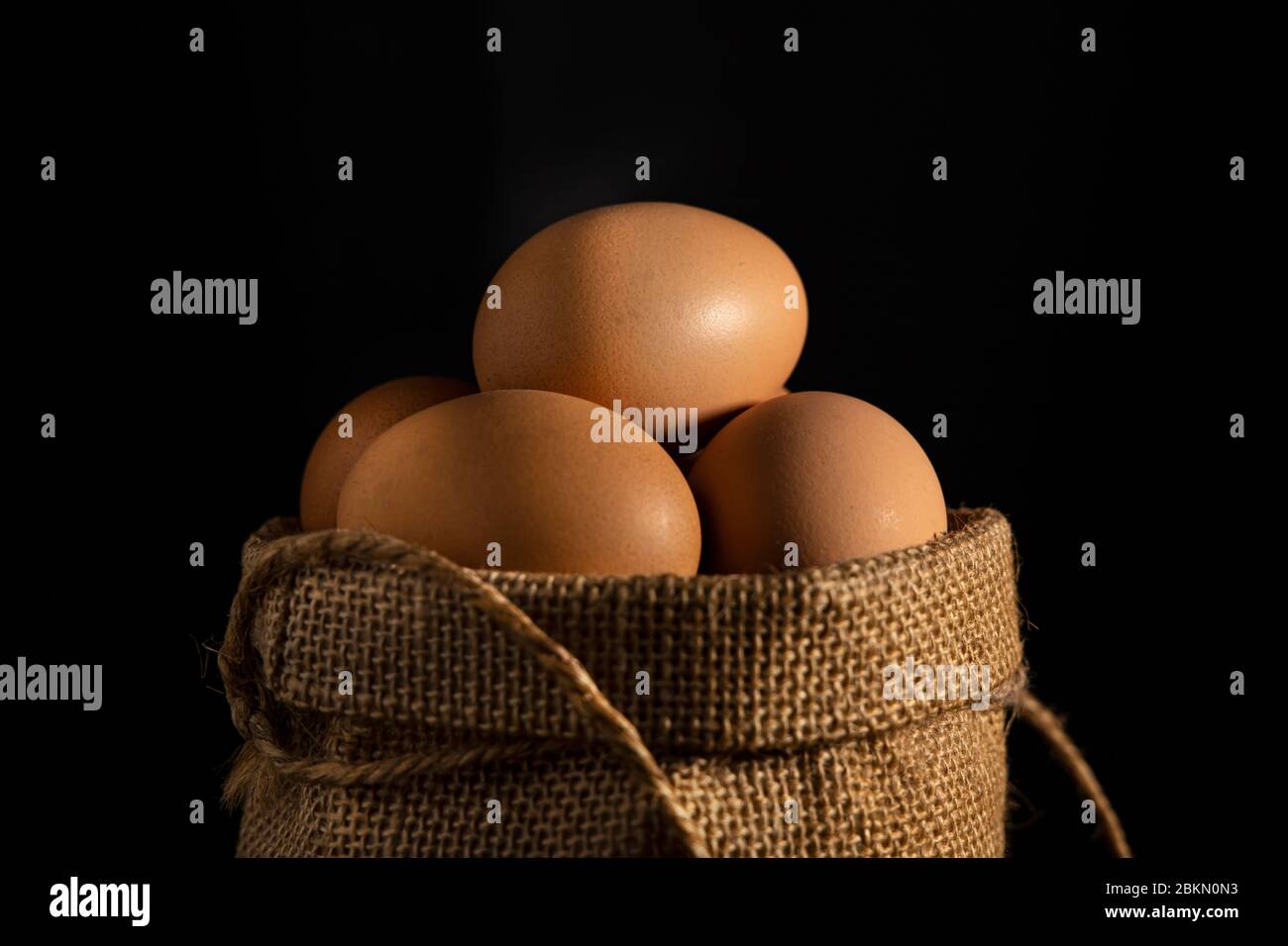 Close up egg in cotton sack on black background. Stock Photo