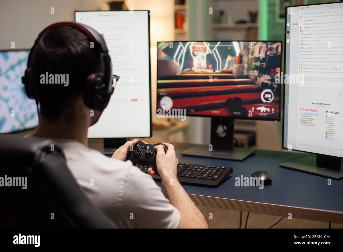 Back shot of pro gamer playing online shooter game on computer using  wireless controller. Competitive player man winning videogame tournament  use professional equipment at home gamming studio Stock Photo - Alamy