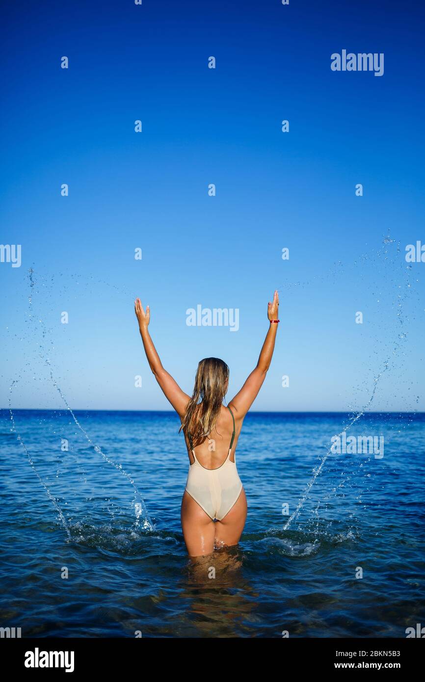 Girl in light swimsuit to bathe in the blue water of the red sea Stock