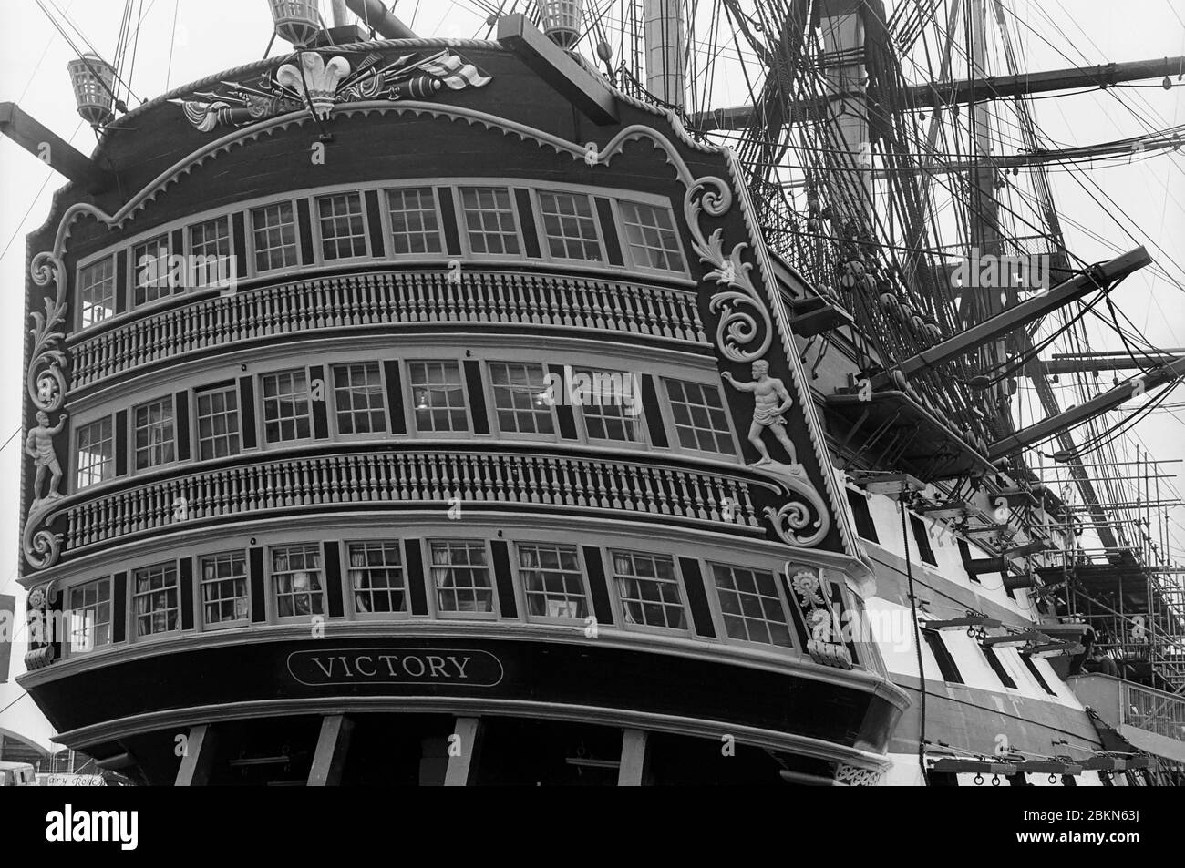 Close-up of the stern galleries of H.M.S. Victory, Nelson's flagship at the Battle of Trafalgar, in No. 2 Dry Dock, Portsmouth Historic Dockyard, Hampshire, England, before 2011, when the topmasts were removed for restoration.  Black and white film photograph Stock Photo