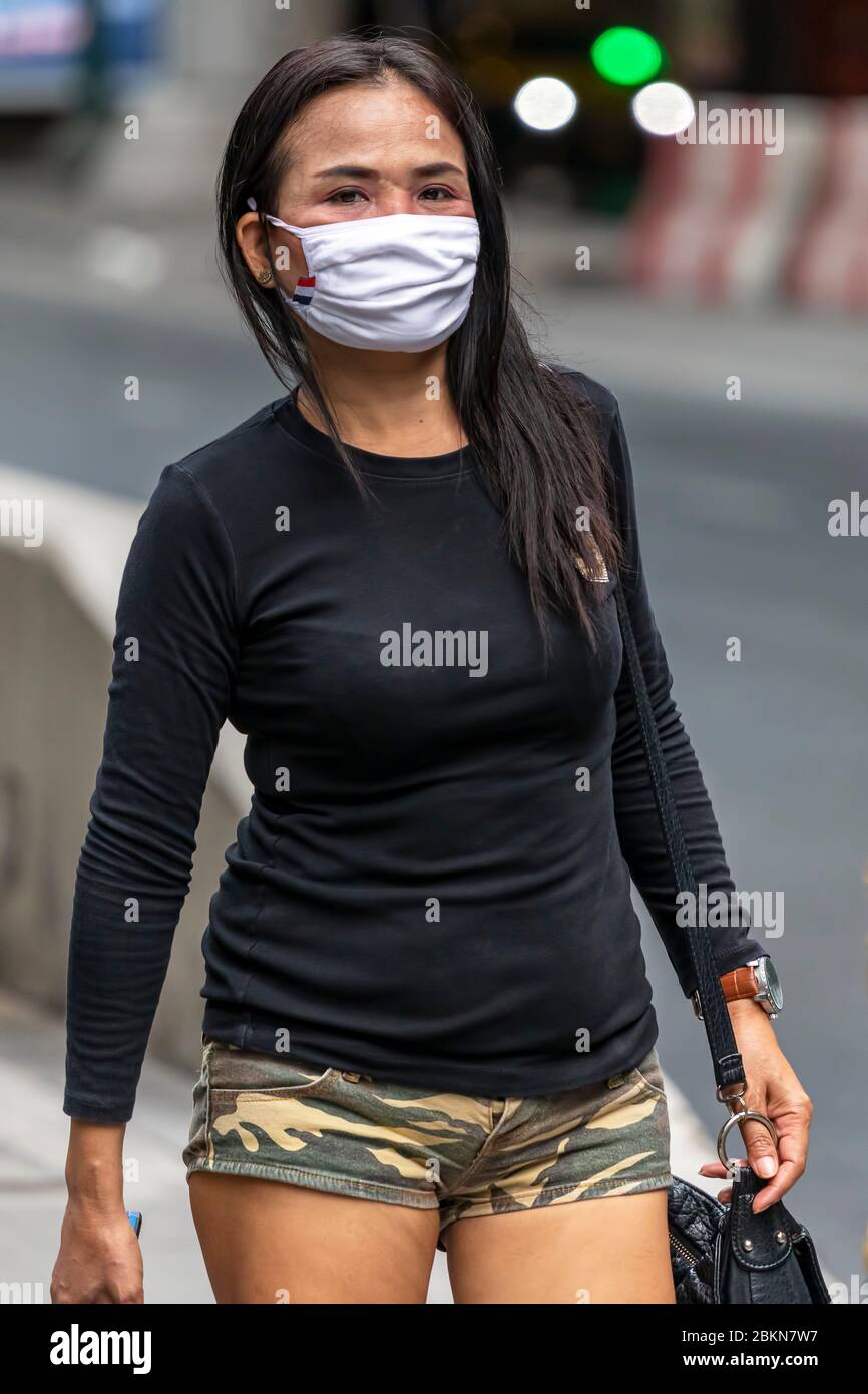 Asian girl wearing face mask walking in the street during Covid 19