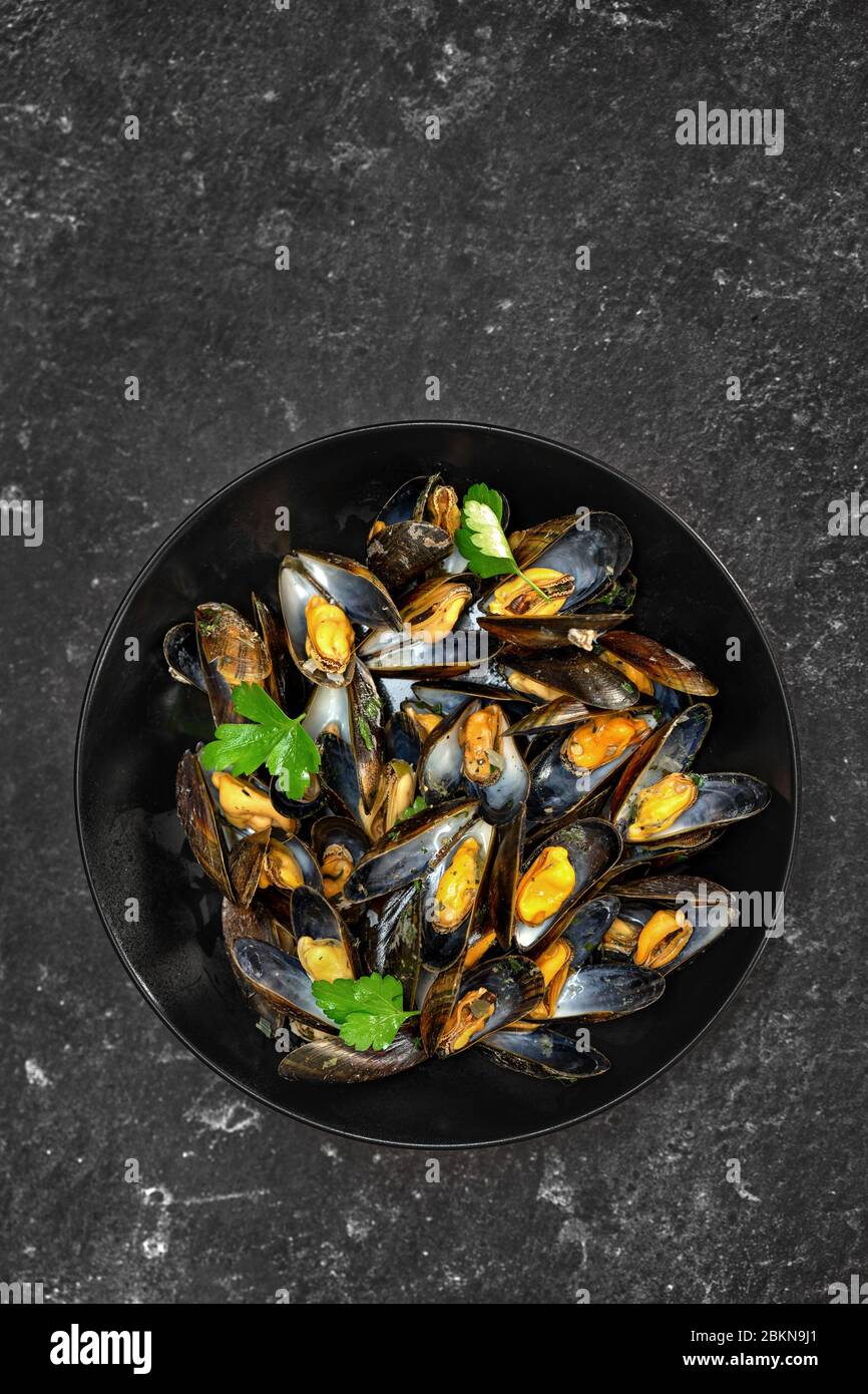 Top view of delicious freshly cooked mussels on black background Stock Photo