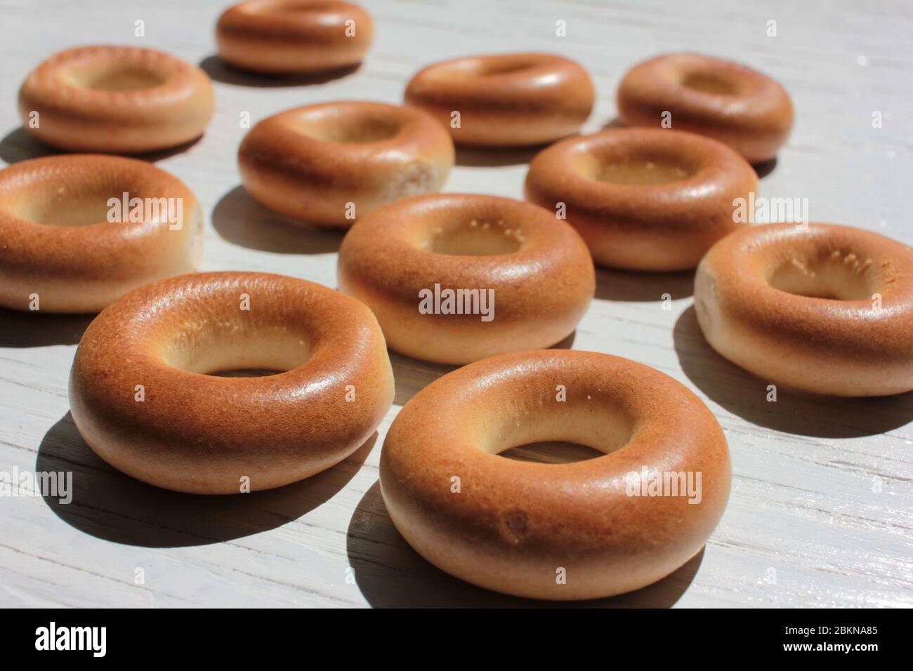 Small dry bagels for kids on white wooden background. First solid