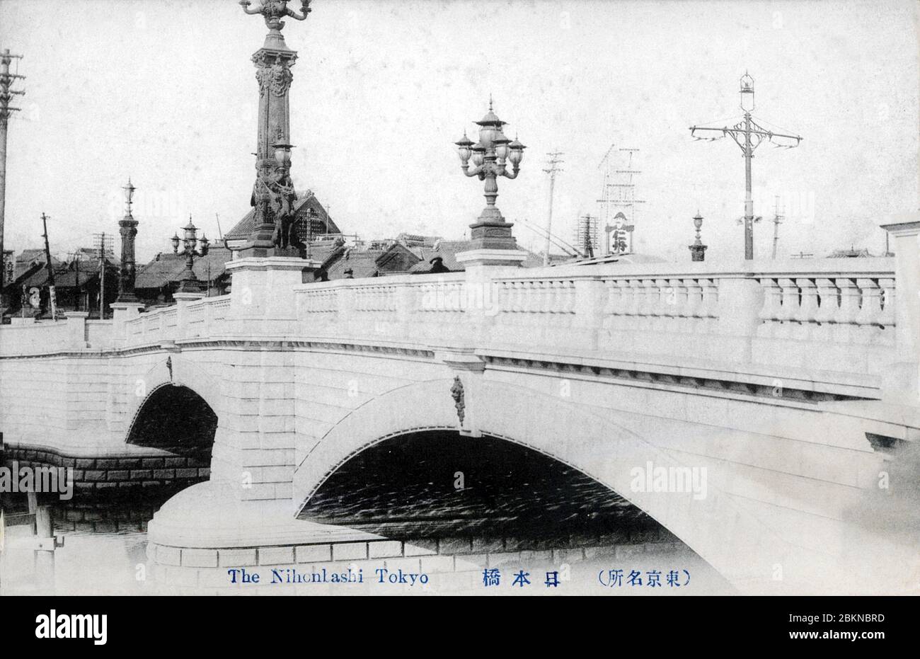 [ 1910s Japan - Nihonbashi Bridge in Tokyo ] —   Nihonbashi Bridge in Tokyo, designed by Yorinaka Tsumaki (妻木頼黄, 1859-1916).  During the Edo Period (1600-1867), the bridge was the starting point of the famous Tokaido and the other 4 post roads. The stone bridge with bronze lions and wrought-iron gas lamps replaced the wooden one in 1911 (Meiji 44).  Now hidden below an ugly highway, it is one of only two surviving Meiji-era bridges in Tokyo.  20th century vintage postcard. Stock Photo