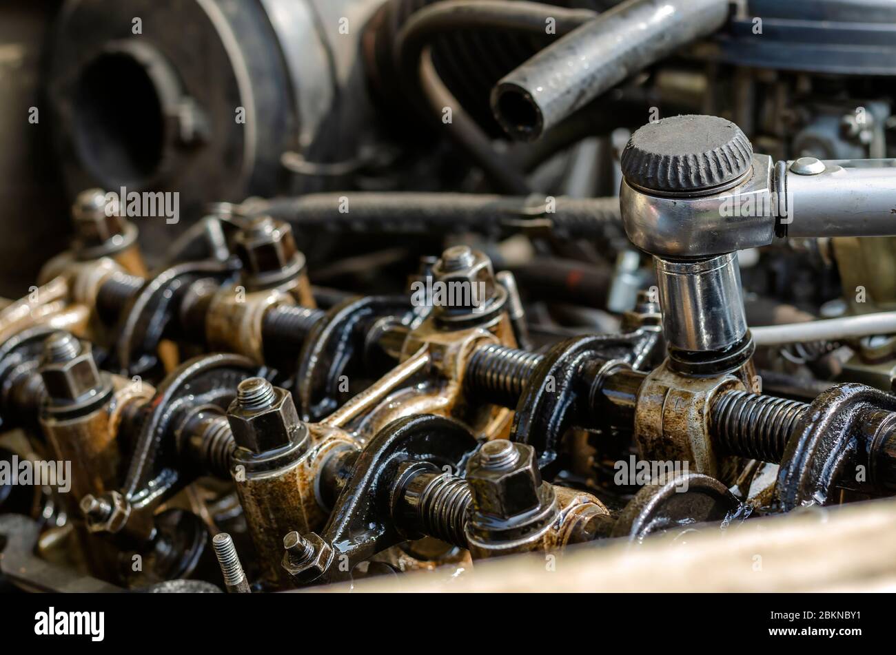 The engine compartment of a passenger car closeup. Tightening the cylinder head. Manual