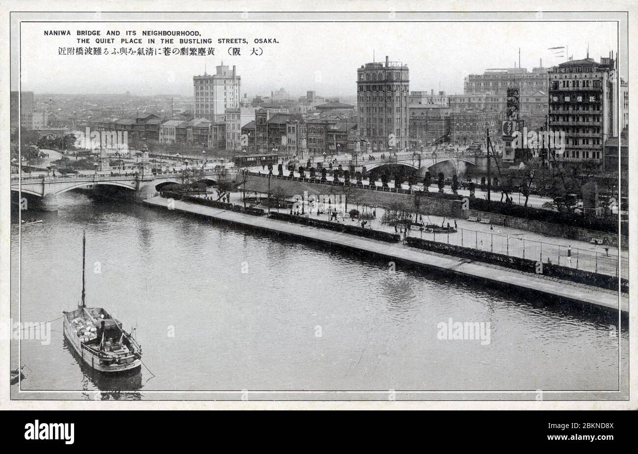 [ 1920s Japan - Naniwabashi Bridge, Osaka ] —   Naniwabashi Bridge spans the Old Yodo River and was completed in 1915 (Taisho 4).  The bridge was, and still is, well known for its lampposts and stone statues of lions. It featured impressive stone steps leading to Nakanoshima Island and the waterfront park which was under construction at the time the bridge was built.  20th century vintage postcard. Stock Photo