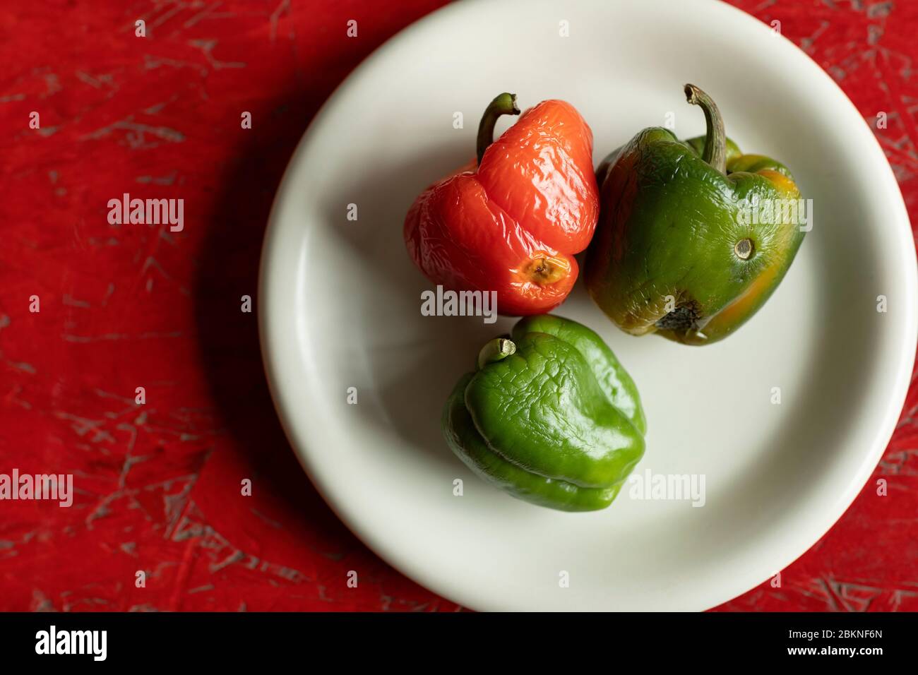 Rotten Red And Green Bell Peppers On A White Plate And A Wooden Red Textured Background Food Waste Compost Flat Lay Shot Horizontal Stock Photo Alamy