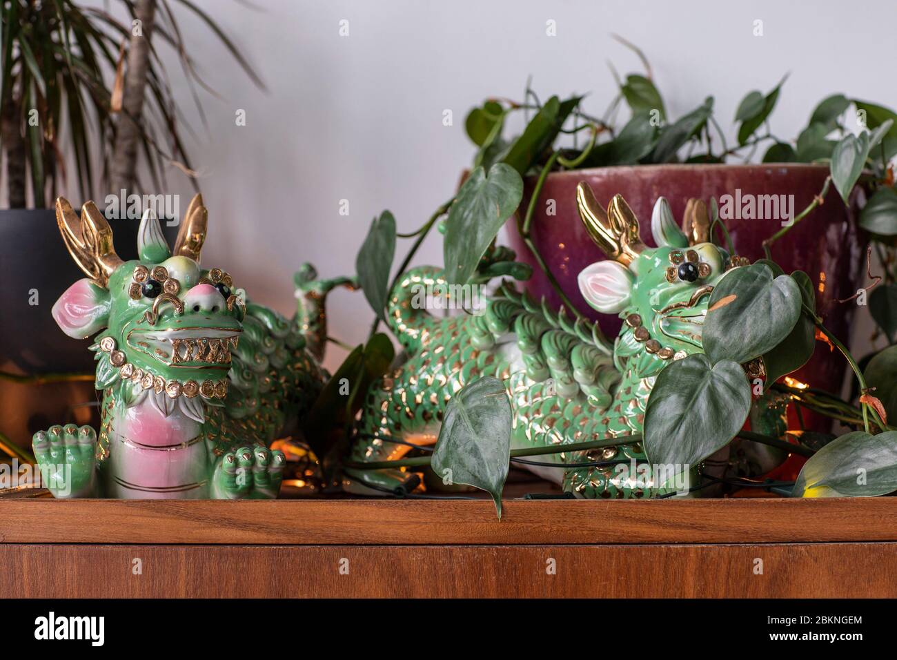 A detail of two green and gold colorful traditional Chinese ceramic dragon statues in a city loft interior on Strijp S, Eindhoven. A bohemian, modern, Stock Photo