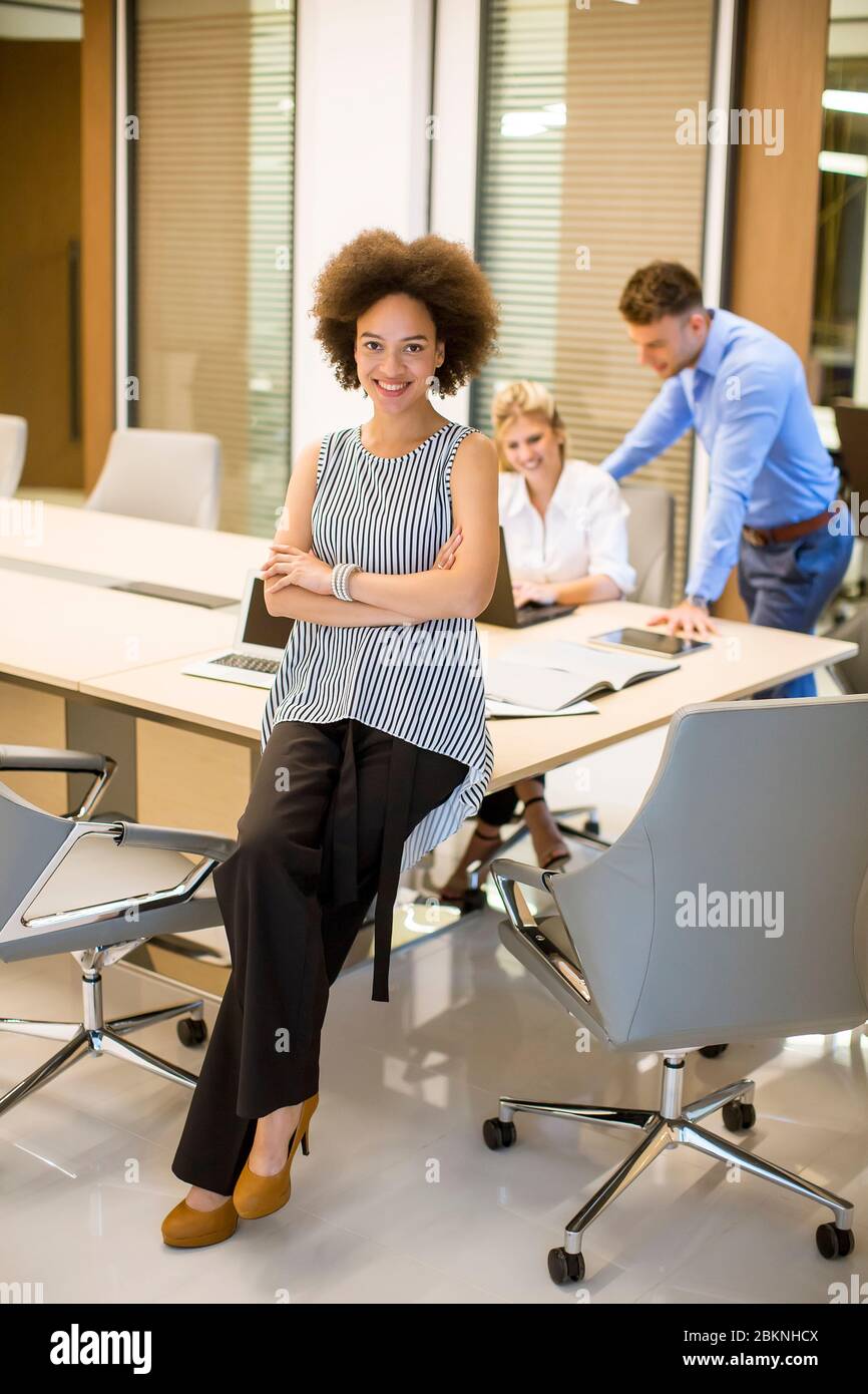 Pretty young african american woman standing in a modern office Stock ...
