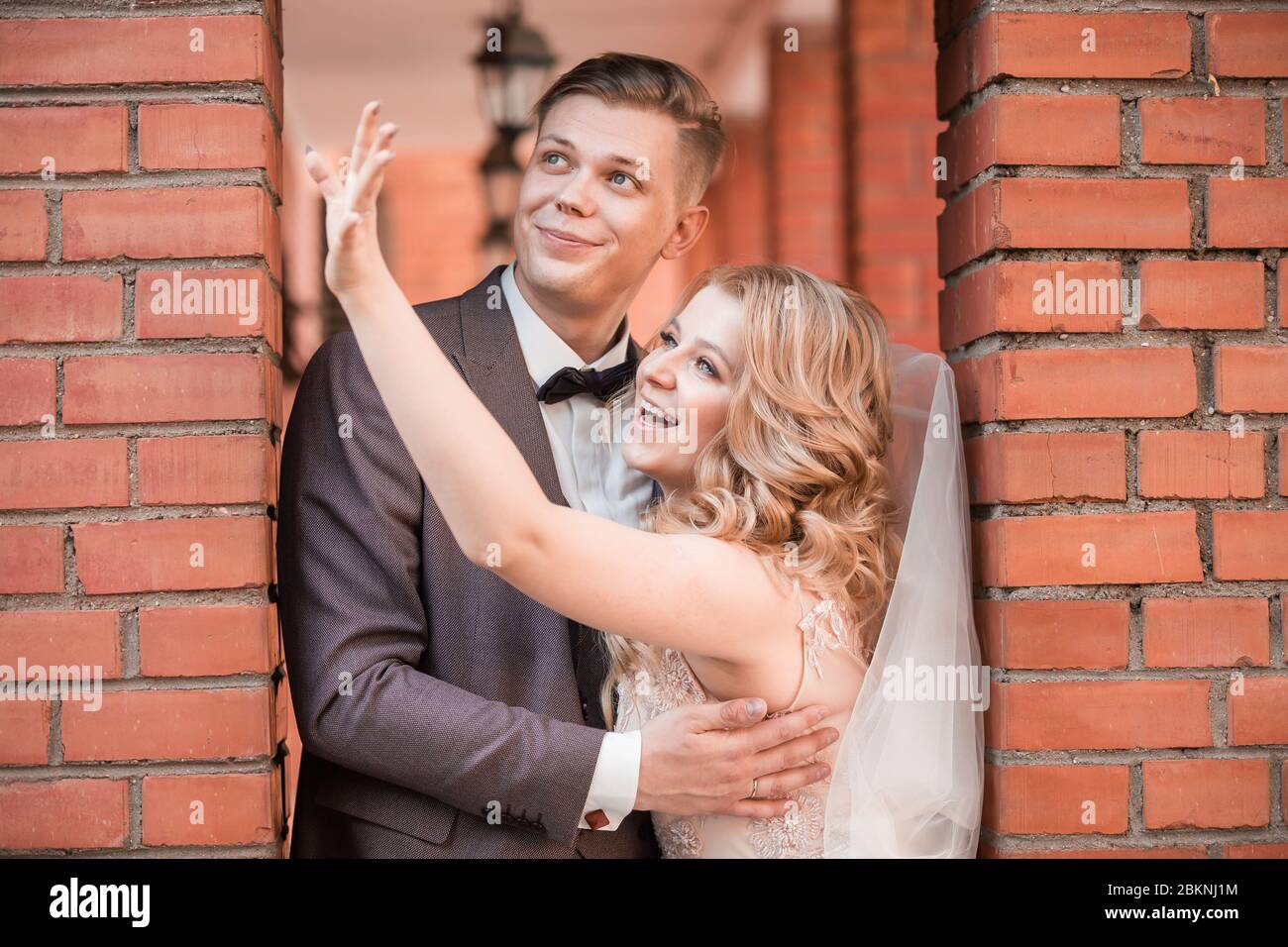 happy newlywed couple hugging each other while walking Stock Photo - Alamy