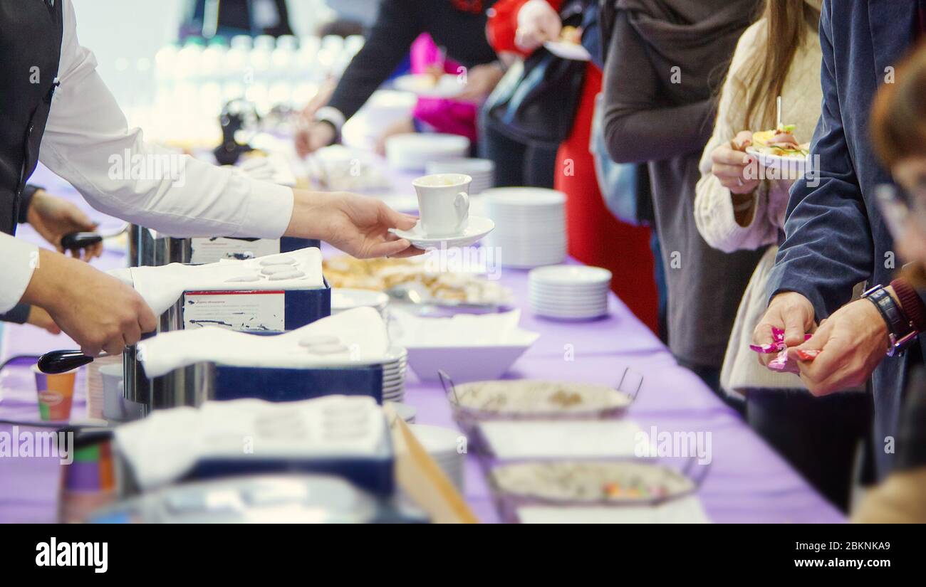 The hands of waiter serving coffee at a coffee break at a business conference Stock Photo