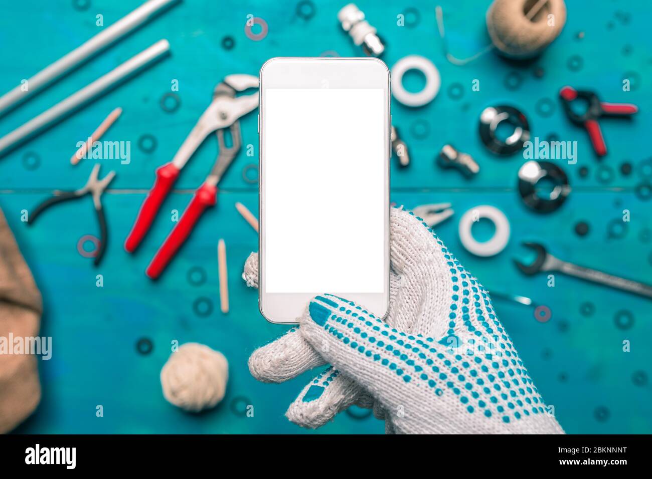 Plumbing app for mobile phones mock up, plumber holding smartphone with blank screen Stock Photo