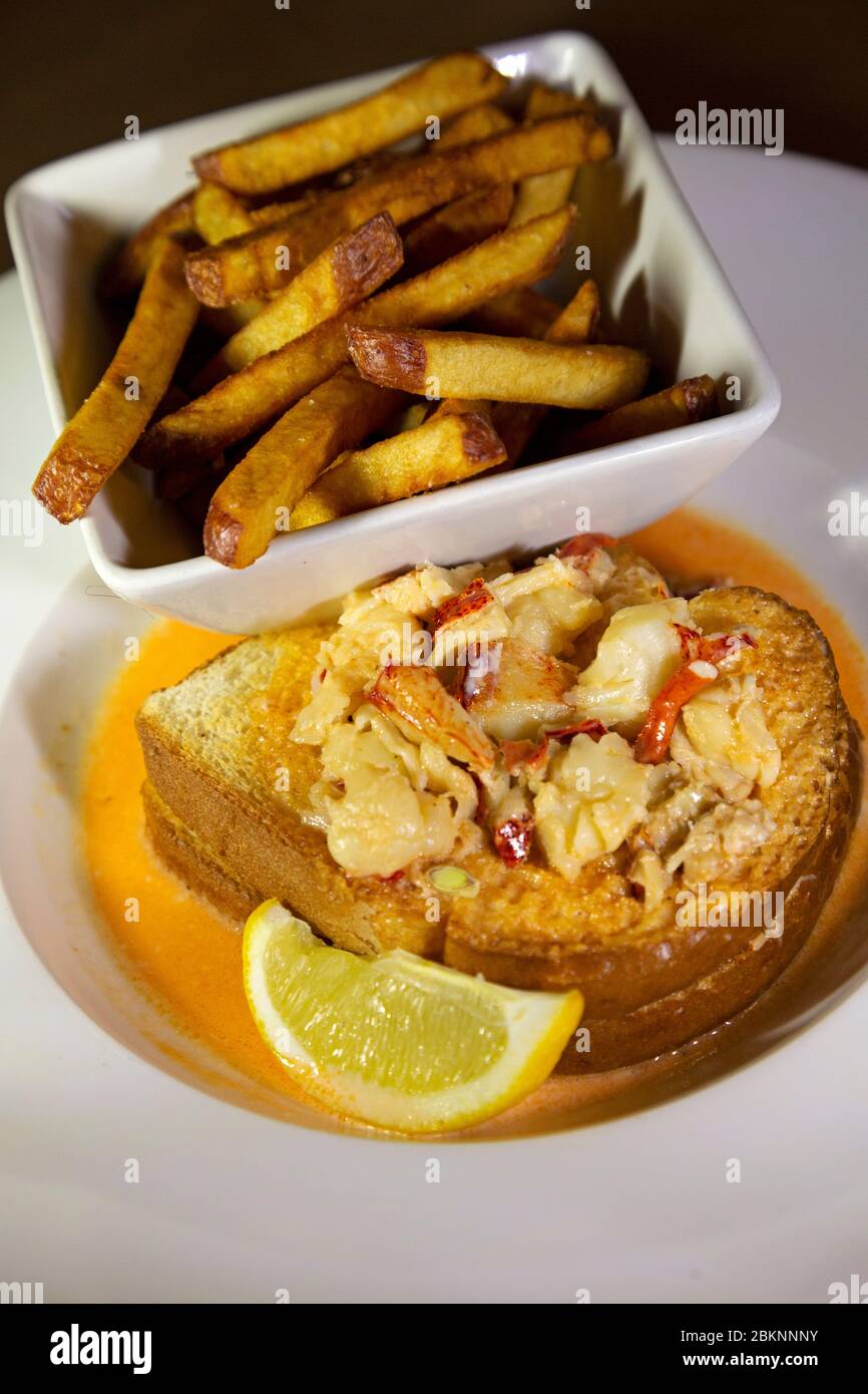 Creamed lobster served on toasted bread with a side of French fries in Barrington, Nova Scotia, Canada. Lobster is a locally landed delicacy in the Ca Stock Photo