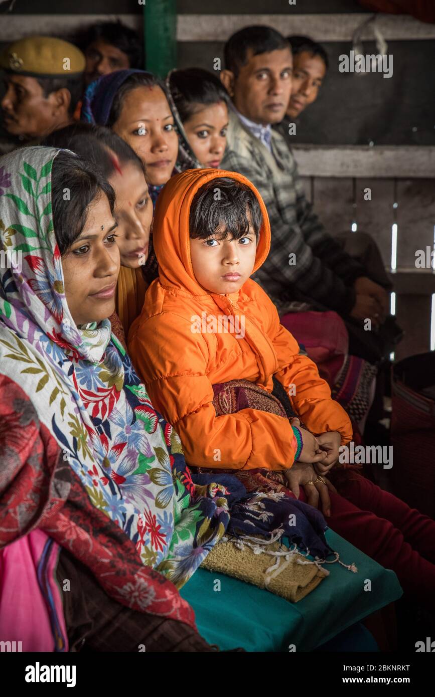 Portrait of a boy sat on mother's lap. Passengers on board a ferry crossing the mighty Brahmaputra river to Majuli Island, Assam, India Stock Photo