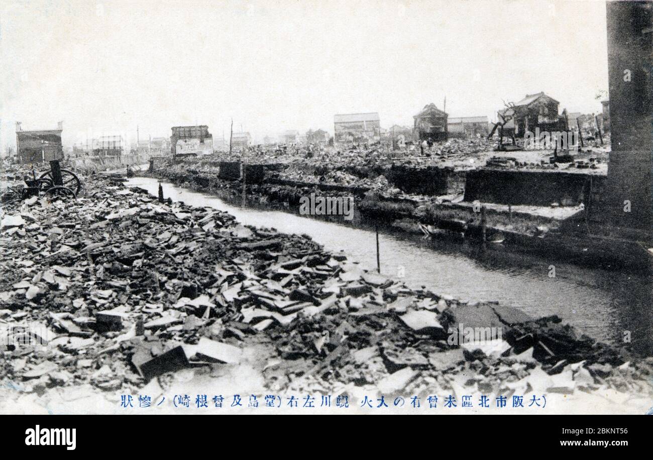 [ 1900s Japan - Great Kita Fire, Osaka ] —   The area around Dojima after the Great Kita Fire (キタの大火, Kita no Taika) of July 31, 1909 (Meiji 42) in Osaka.  The river in the center is Shijimigawa. The fire destroyed 14,067 houses and buildings and became the impetus for the creation of the Osaka fire fighting dept. As a result of the fire, glass lamps were banned and replaced by metal ones, and the authorities began promoting the use of electricity.  20th century vintage postcard. Stock Photo