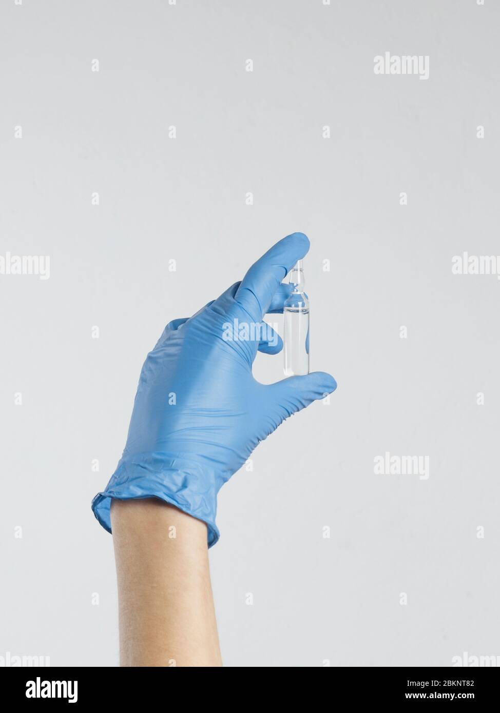 Vaccination Coronavirus Covid-19 Concept. Hand in medical glove holds ampoule with vaccine Stock Photo