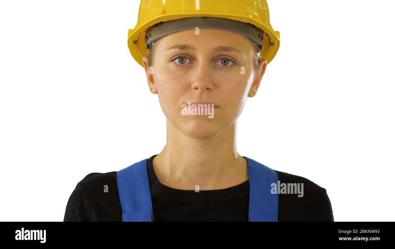 Young attractive caucasian woman builder in the hard yellow helmet on white background. Stock Photo