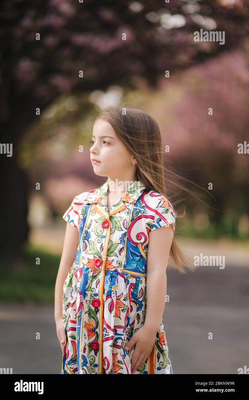 Young girl model poses to photographer. Female kid i beautiful dress  outside Stock Photo - Alamy