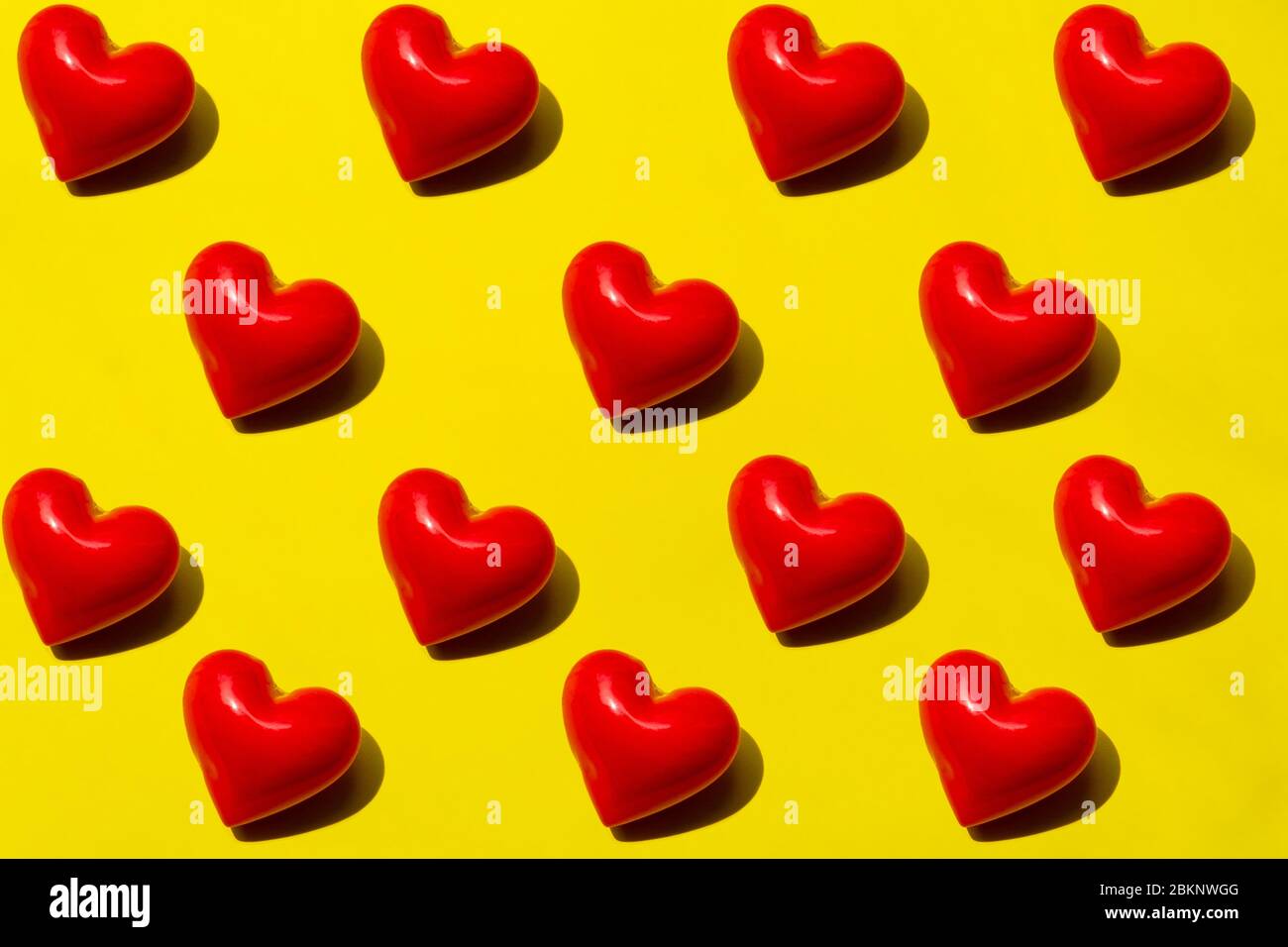 Seamless Red hearts pattern on yellow background. Top view, flat lay, layout. Romantic colorful pattern. Stock Photo