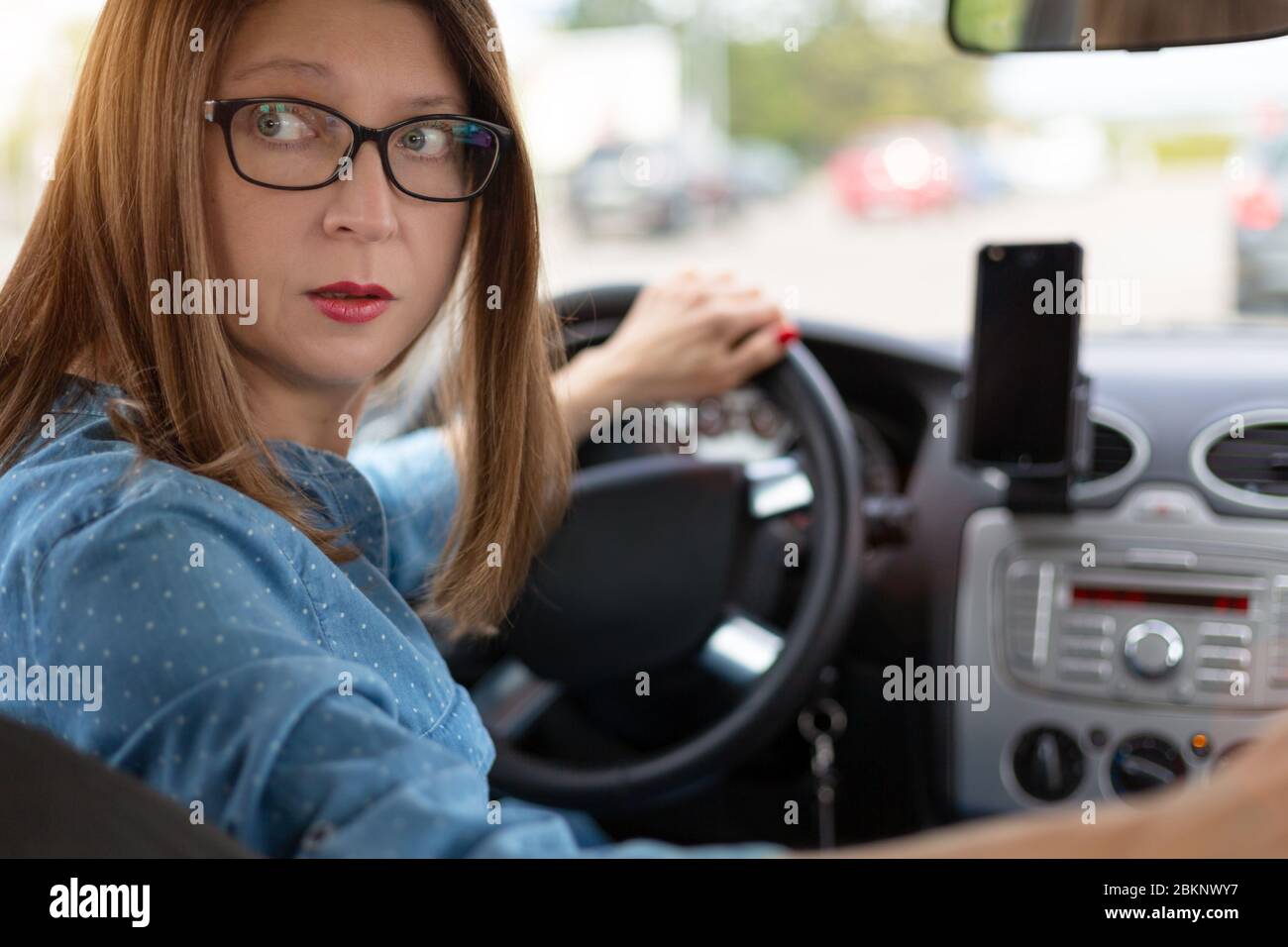 A woman driving the car backwards Stock Photo