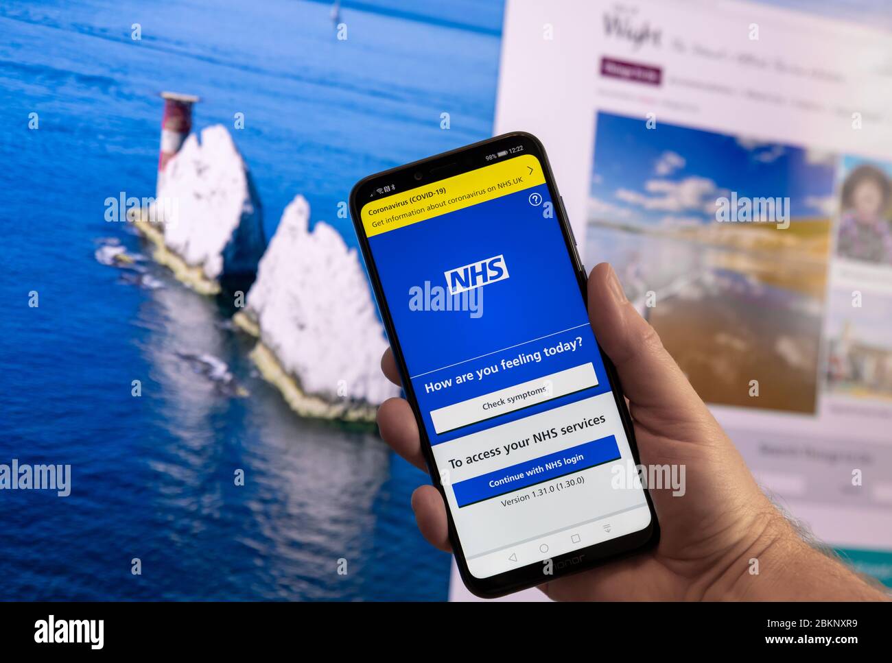 Dorset, UK. Tuesday 5 May 2020. NHS contact tracing app is launched on the Isle of Wight in the UK. Smartphone shown with the NHS app and landmark The Needles behind. Credit: Thomas Faull/Alamy Live News Stock Photo