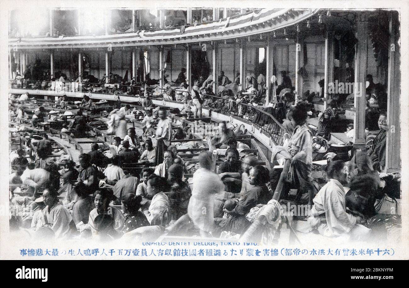 [ 1910s Japan - Great Kanto Flood, Tokyo ] —   People displaced by the flooding of August 1910 (Meiji 43), now known as the Great Kanto Flood (関東大水害, Kanto Dai Suigai) are taking shelter at Kokugikan Sumo Hall in Tokyo. The hall had just been opened the previous year.  The flood, caused by a storm, submerged more than 201 square kilometers and over 170,000 dwellings and buildings. There were 1,349 dead or missing. It was Tokyo’s third worst flood disaster of the 20th century.  20th century vintage postcard. Stock Photo