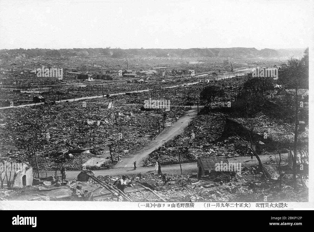 [ 1920s Japan - Yokohama Destroyed by the Great Kanto Earthquake ] —   The ruins of Yokohama after the Great Kanto Earthquake of September 1, 1923 (Taisho 12). The photographer took this sobering photo from  Noge-Yama.  The quake, with an estimated magnitude between 7.9 and 8.4 on the Richter scale, devastated Tokyo, the port city of Yokohama, surrounding prefectures of Chiba, Kanagawa, and Shizuoka, and claimed over 140,000 victims.  Photo number 1 of 4.  20th century vintage postcard. Stock Photo