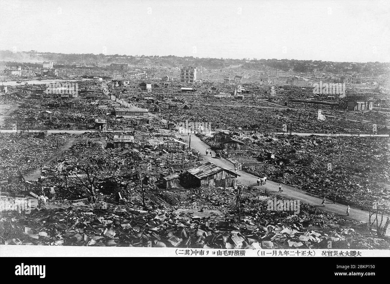 [ 1920s Japan - Yokohama Destroyed by the Great Kanto Earthquake ] —   The ruins of Yokohama after the Great Kanto Earthquake of September 1, 1923 (Taisho 12). The photographer took this sobering photo from  Noge-Yama.  The quake, with an estimated magnitude between 7.9 and 8.4 on the Richter scale, devastated Tokyo, the port city of Yokohama, surrounding prefectures of Chiba, Kanagawa, and Shizuoka, and claimed over 140,000 victims.  Photo number 2 of 4.  20th century vintage postcard. Stock Photo