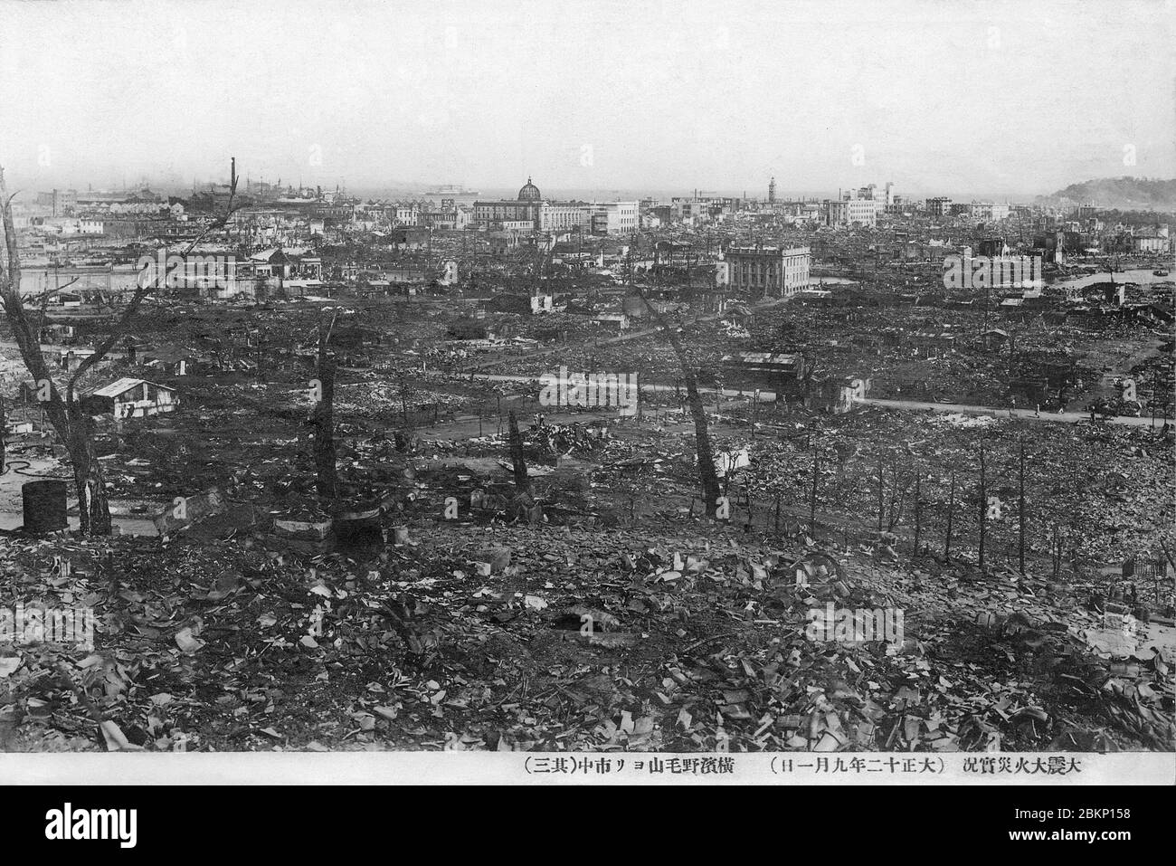 [ 1920s Japan - Yokohama Destroyed by the Great Kanto Earthquake ] —   The ruins of Yokohama after the Great Kanto Earthquake of September 1, 1923 (Taisho 12). The photographer took this sobering photo from  Noge-Yama.  The quake, with an estimated magnitude between 7.9 and 8.4 on the Richter scale, devastated Tokyo, the port city of Yokohama, surrounding prefectures of Chiba, Kanagawa, and Shizuoka, and claimed over 140,000 victims.  Photo number 3 of 4.  20th century vintage postcard. Stock Photo