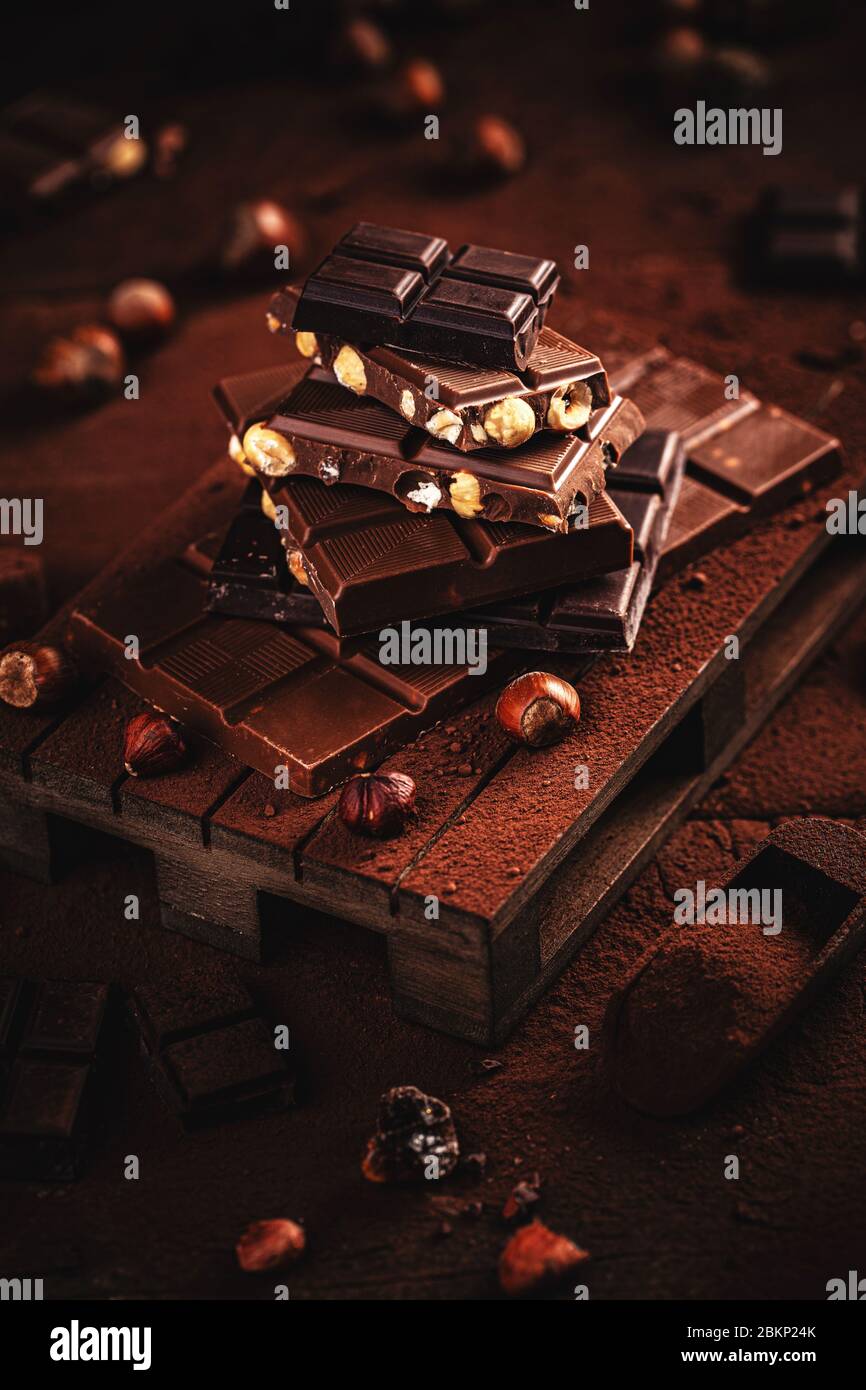Chocolate pieces with hazelnut on dark wooden background Stock Photo
