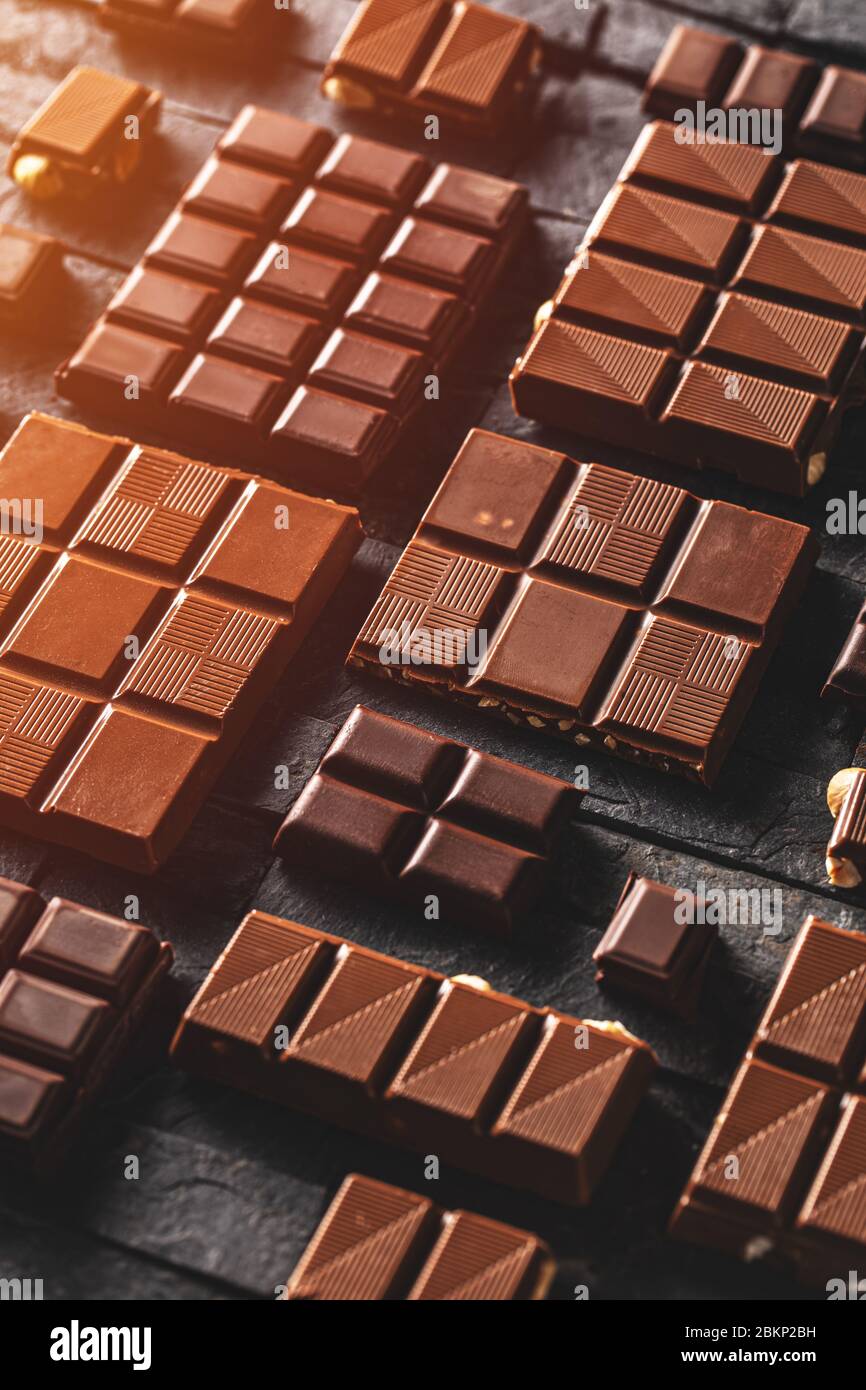 Milk and hazelnut chocolate pieces on black background Stock Photo