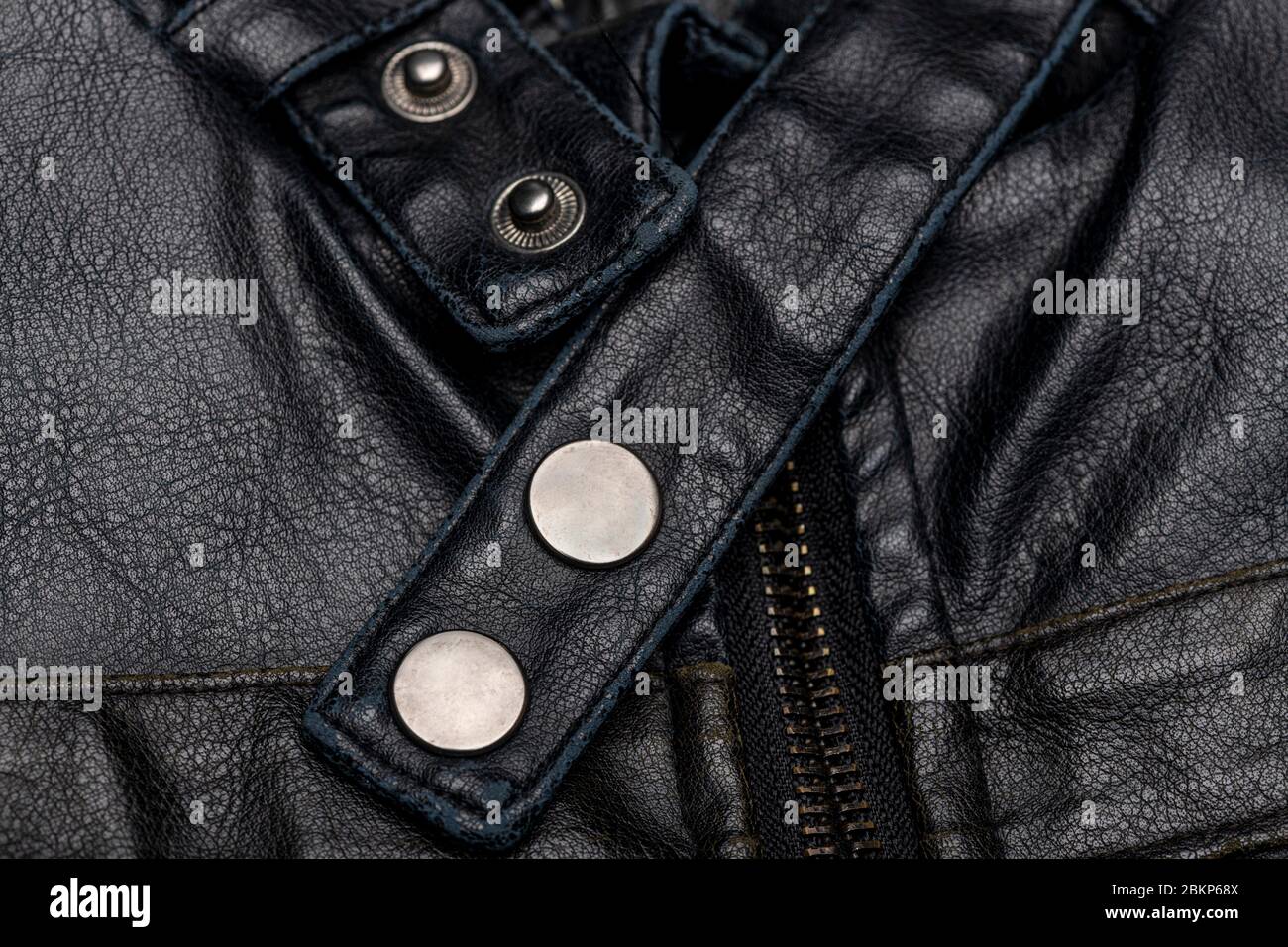 close up of a black leather vintage motorcycle jacket, zipper and press studs. Stock Photo
