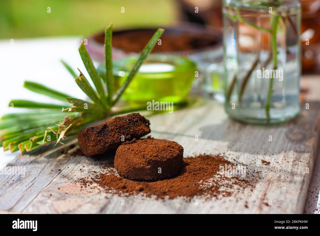 Leaves of a palm tree and coffee grounds on wooden table. Coffee