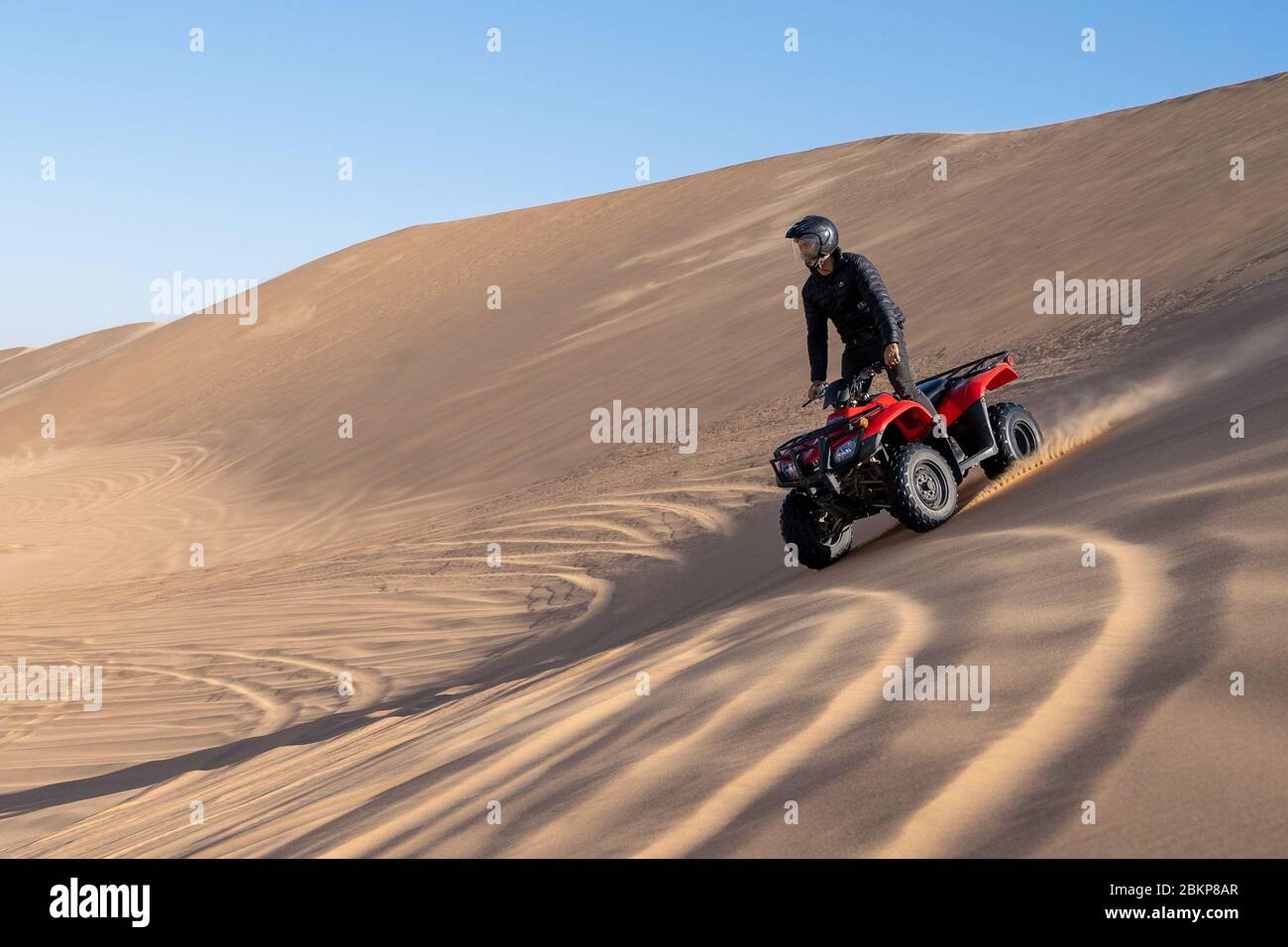 Man in black on red quad bike tour in the desert near Swakopmund, Namibia Stock Photo